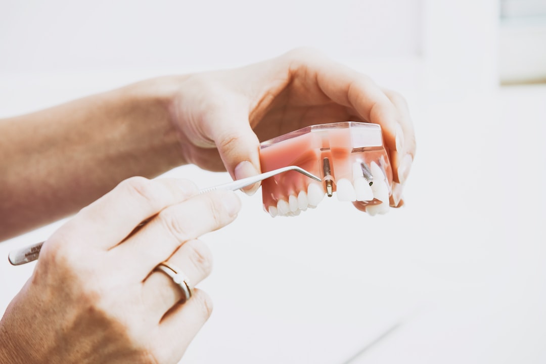 Photo by Peter Kasprzyk person wearing silver-colored ring while holding denture